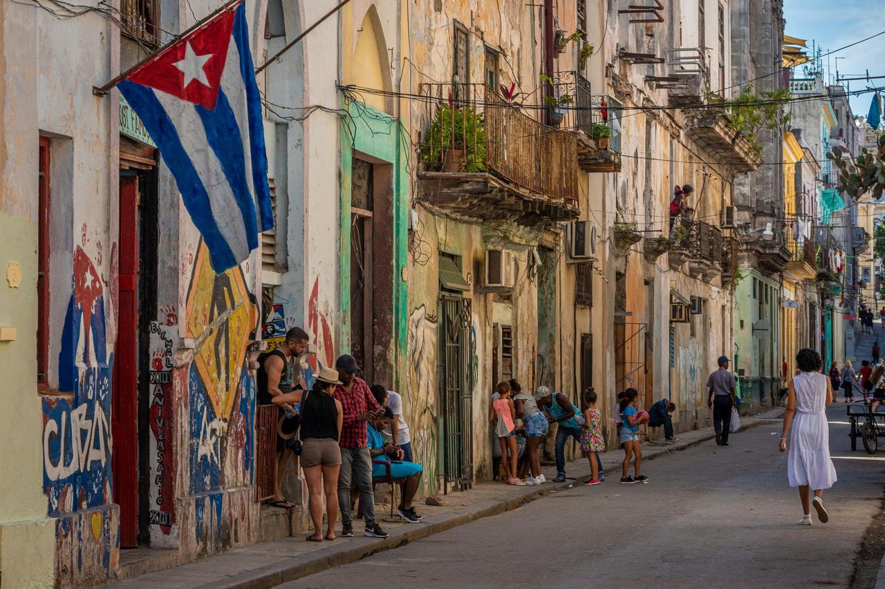 Havana street with balconies, facades, and a Cuban flag